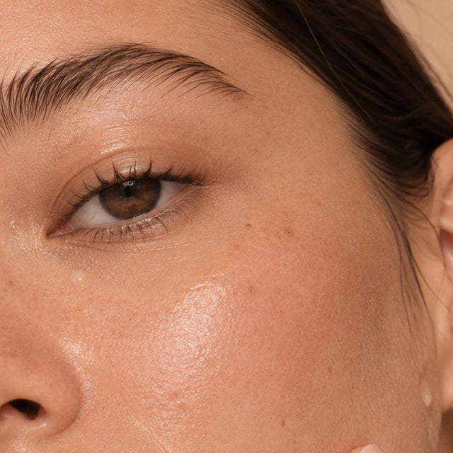 Œil brun d'une femme en gros plan, peau brillante, routine douce pour peau grasse