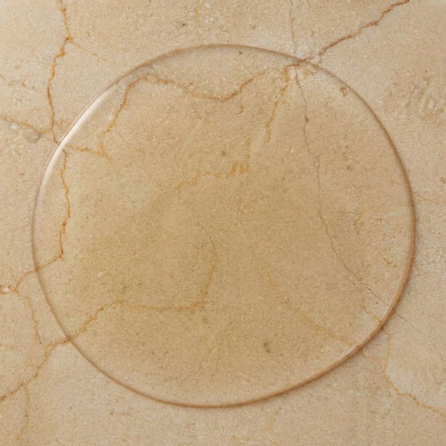Goutte de gel cosmétique transparent étalée en cercle sur un marbre beige veiné