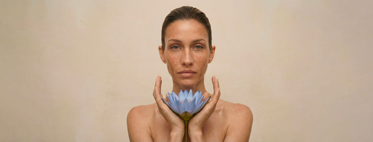 Femme tenant une fleur de lotus bleu au creux des mains, la mission cosmétique holistique Just avant