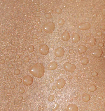 Gouttes d'eau et de brume perlant sur la peau en gros plan, hydratation du visage