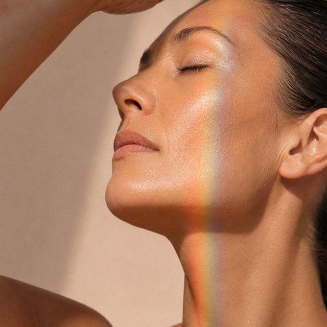Femme de profil les yeux fermés, reflet de lumière irisée d'écran sur le visage et le cou