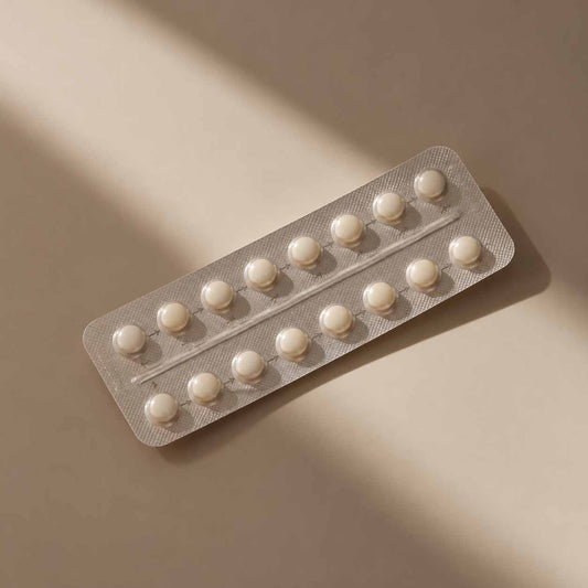 Plaquette de comprimés contraceptifs sur fond beige dans une lumière douce