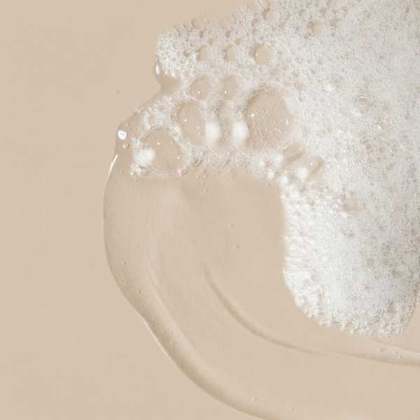 Texture de gel nettoyant naturel et mousse fine aux bulles délicates sur fond beige