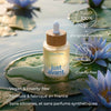Flacon du sérum anti-âge Lotus bleu Just avant posé sur des feuilles de lotus, vegan et formulé en France