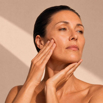Femme posant ses mains sur la joue et sous le menton, geste de massage du visage