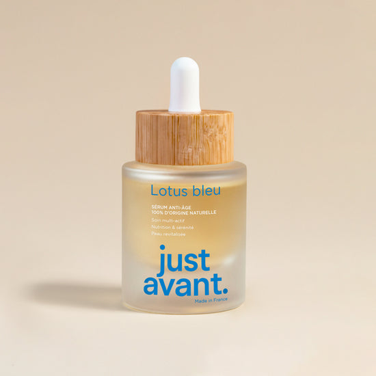 Sérum visage Lotus Bleu Just avant. dans un flacon en verre givré avec pipette blanche et bouchon en bois, soin anti-âge 100% d’origine naturelle présenté sur fond clair.