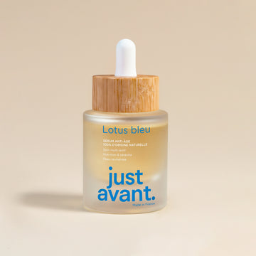 Sérum visage Lotus Bleu Just avant. dans un flacon en verre givré avec pipette blanche et bouchon en bois, soin anti-âge 100% d’origine naturelle présenté sur fond clair.